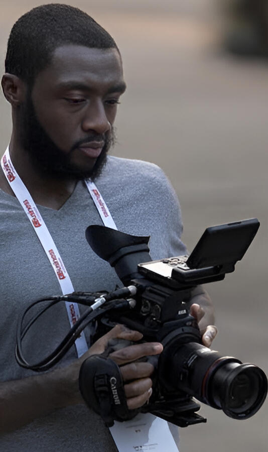 A phot of Austin Dancy taken while operating a camera at an event.